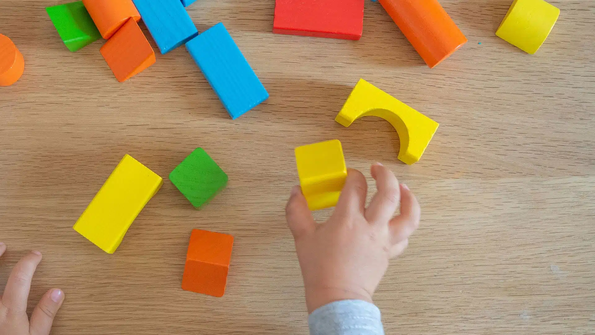 Infant playing with toy blocks.