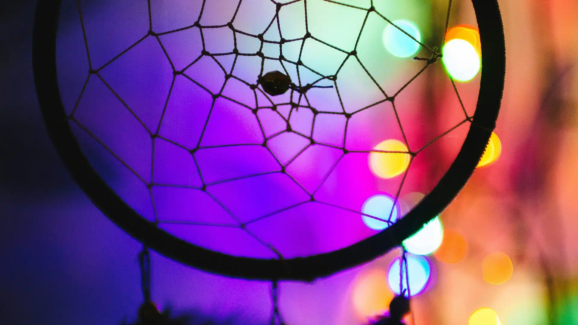 Dreamcatcher silhouette against colorful lights.